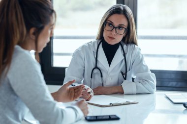 Konsültasyonda hastaya tıbbi tedaviyi açıklarken güzel bir kadın doktorun konuşması..