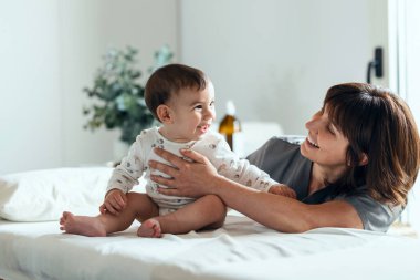 Fizyoterapi odasında erkek bebeğe masaj ve jimnastik yapan kadın fizyoterapist.. 