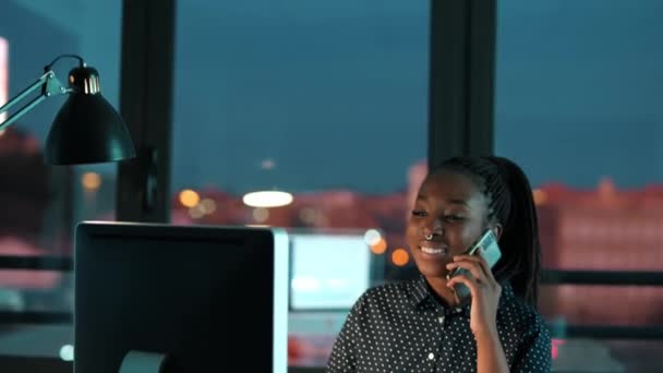 在办公室使用笔记本电脑时 一位自信的年轻商业女性在手机上交谈的视频 — 图库视频影像