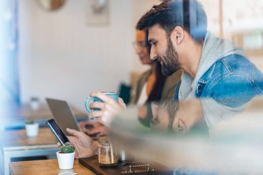 Çevre barında kahve içerken akıllı telefonunu kullanan yakışıklı bir delikanlının haykırışı..