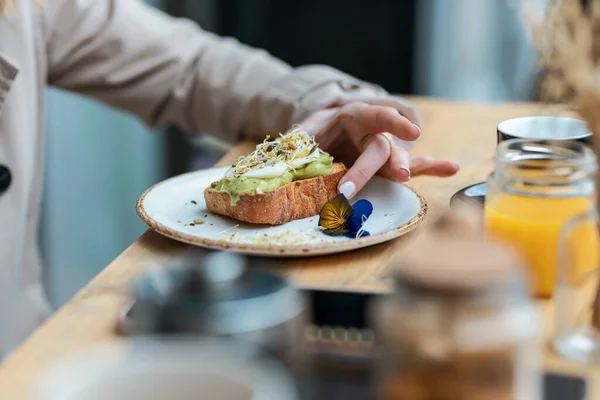 Shot Close Woman Hands Holding Eggs Benedict Toast Advocado Breakfast — Stok fotoğraf