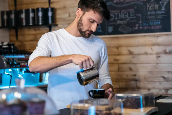 Shot of handsome young waiter preparing natural coffee to serve to customers in a healthy coffee shop