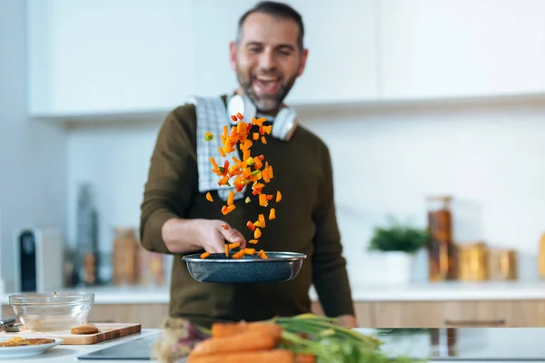 Shot Handsome Mature Man Sauting Vegetables Pan While Having Fun — Foto Stock
