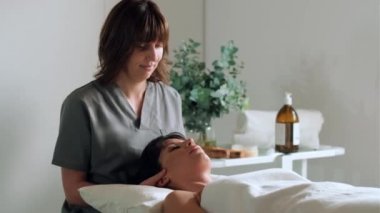 Reiki 'nin bir fizyoterapi odasında hastayı iyileştirdiği kadın fizyoterapistin boyun ve yüz tedavisi videosu.. 