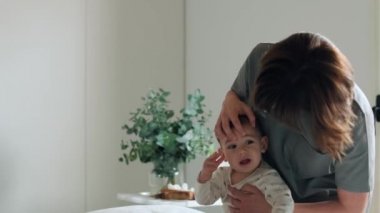 Fizyoterapi odasında erkek bebeğe masaj ve jimnastik yapan kadın fizyoterapistin videosu.. 