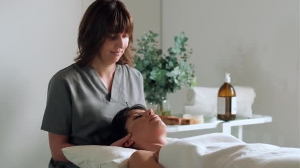 Video Female Physiotherapist Doing Neck Face Treatment While Having Reiki — Stockvideo