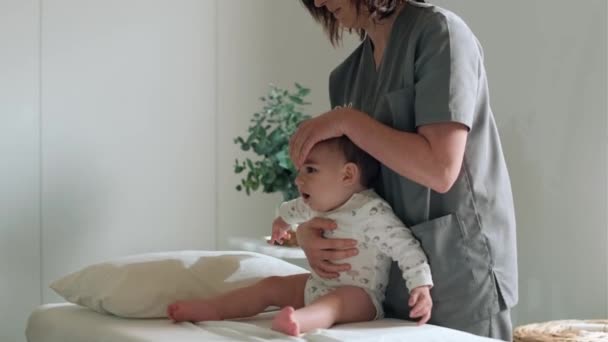 Fizyoterapi Odasında Erkek Bebeğe Masaj Jimnastik Yapan Kadın Fizyoterapistin Videosu — Stok video