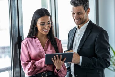 Modern başlangıçta konferans odasında konuşurken dijital tabletle çalışan çok yönlü iş adamlarının çekimi.
