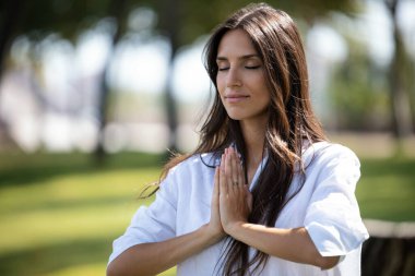 Shot of beautiful young woman doing yoga and meditation in a park.