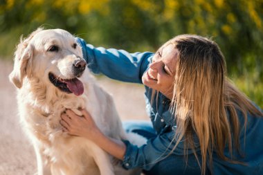 Tecavüze uğramış bir tarlada güzel Golden Retriever köpeğiyle oynayan çekici bir genç kadın..