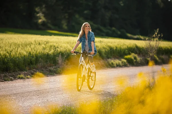 Съемка Красивой Молодой Девушки Едущей Велосипеде Через Изнасилованное Поле — стоковое фото