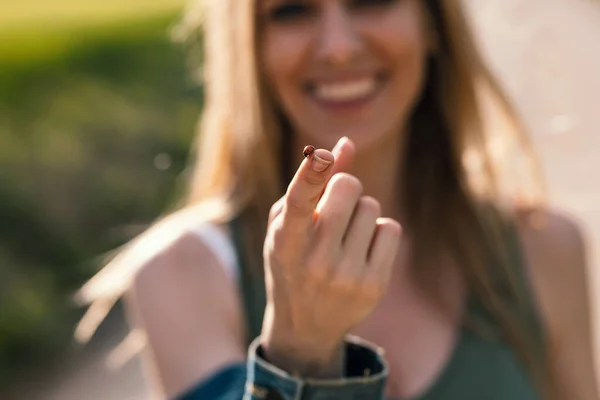 Fotografía Una Hermosa Mujer Sonriente Sosteniendo Una Mariquita Mientras Muestra — Foto de Stock