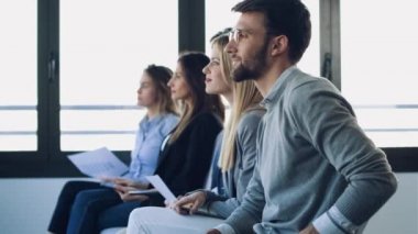 Coworking alanında otururken konferans dinledikten sonra alkışlayan mutlu iş ekibi Video.