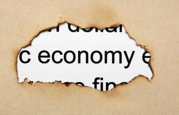 Economie tekst op papier hole — Stockfoto