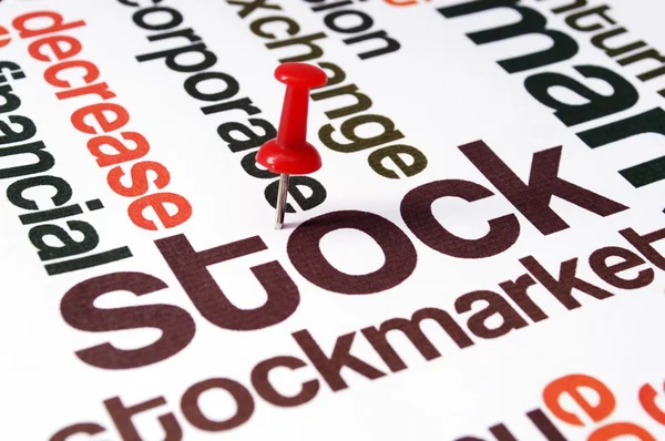 Push pin on stockmarket text — Stock Photo, Image