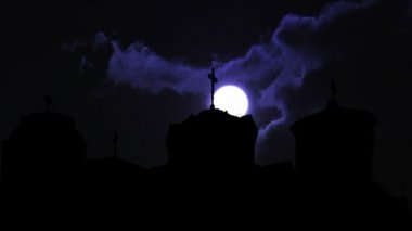 Dolunay kara bulutların üzerinde zaman akıp gidiyor.