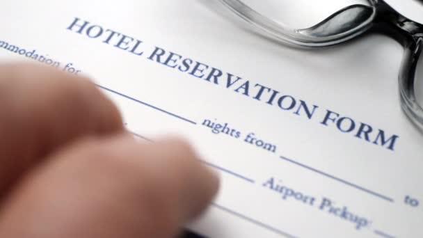 Finger tapping on hotel reservation form — Stockvideo