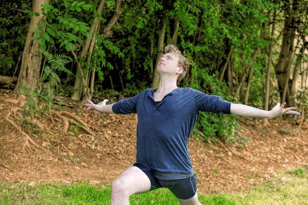 Man Performs Yoga Lunge in Park — Stock Photo, Image