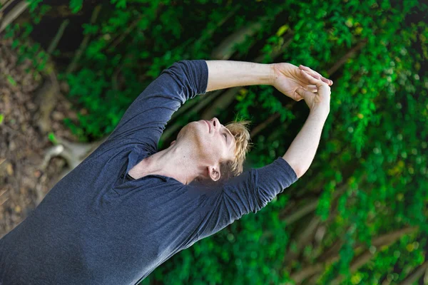 Le jeune homme tend les mains au-dessus de lui — Photo