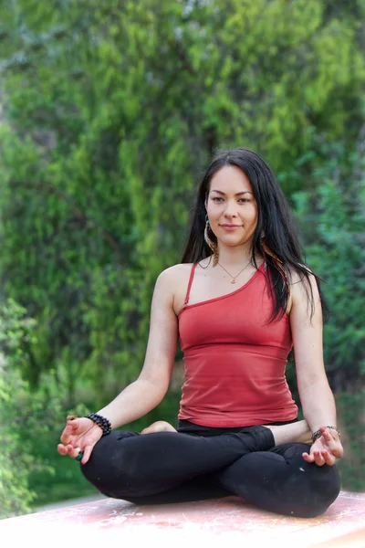 Woman Sits in Yoga Lotus Pose on park table — Stock Photo, Image