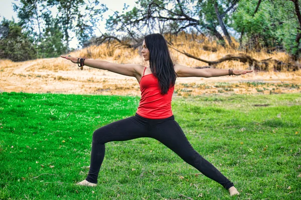 kadın yogi savaşçı poz Park'ta gerçekleştirir.