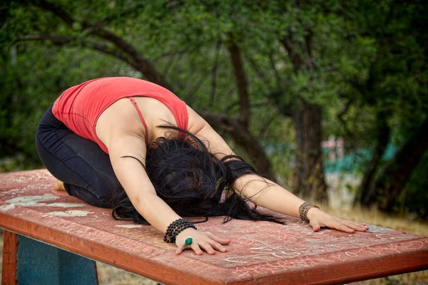 Práticas de mulher Yoga na mesa de piquenique — Fotografia de Stock