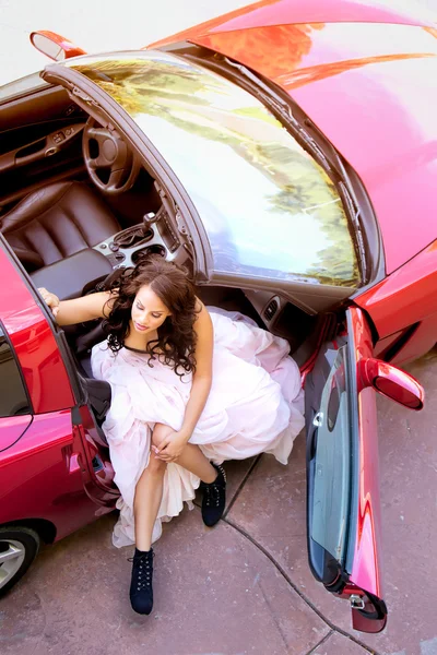 Glamorous Young Woman Getting Out of Red Sports Car Stock Photo