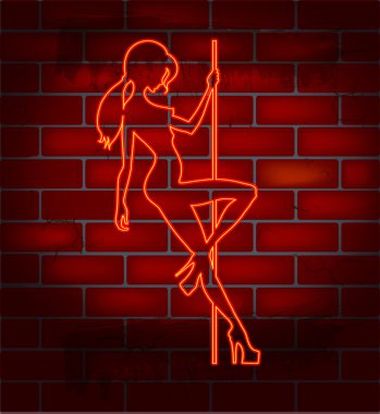 An illuminated neon sign for a strip club mounted on a brick wall clipart