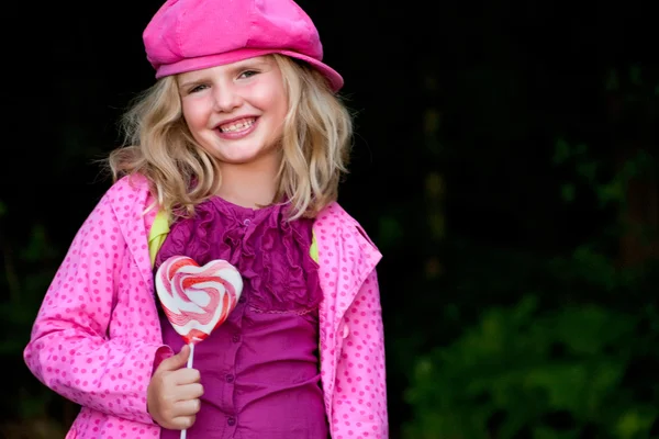 Lächelndes rosa Mädchen mit Lolli — Stockfoto