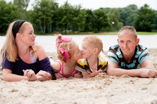 Familia feliz y sus hijos besándose — Foto de Stock