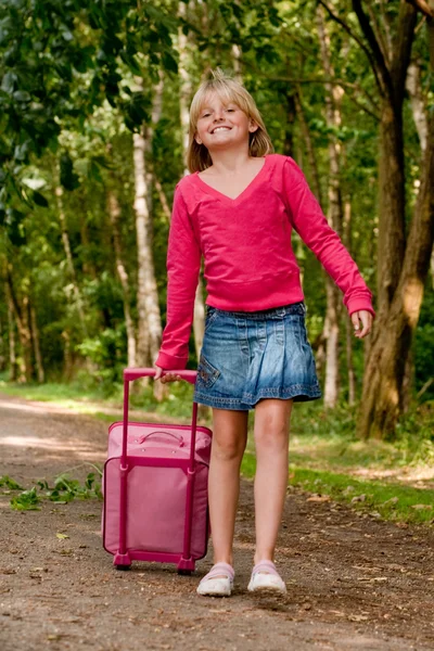 Girl walking with her pink suitcase — Stock Photo, Image