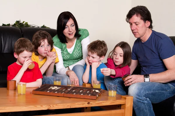 Familjen spelar en brädspel — Stockfoto