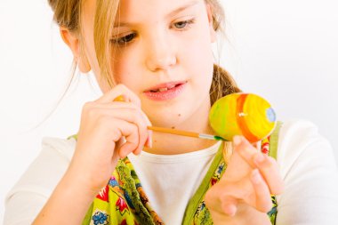 Young girl painting easter eggs clipart