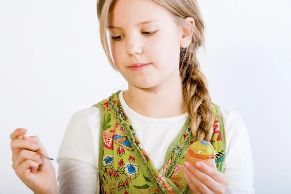 Молодая девушка проверяет свои окрашенные яйца — стоковое фото