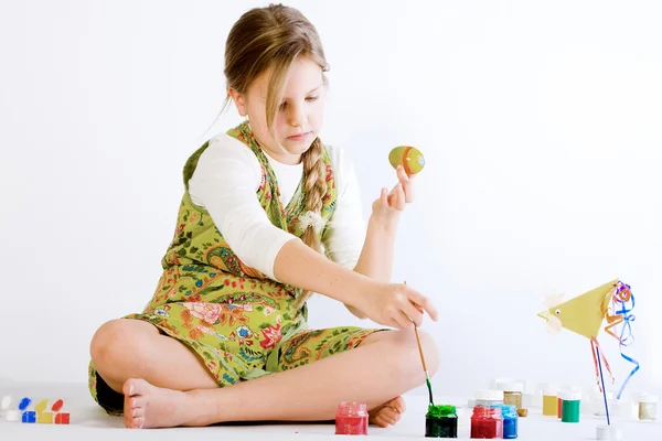 Jong meisje spelen met verf en eieren — Stockfoto