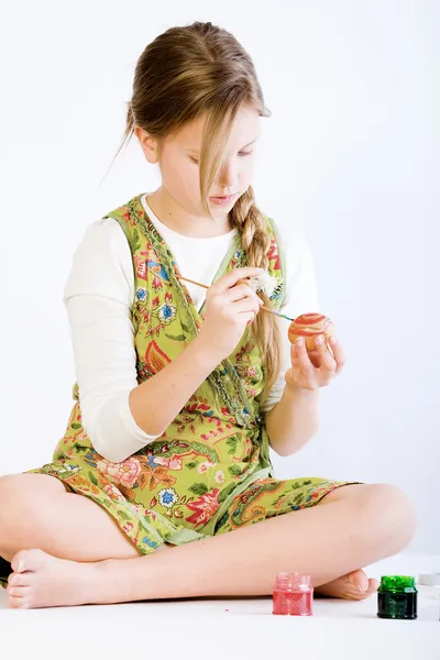 Ung flicka koncentreras målning ägg till påsk — Stockfoto