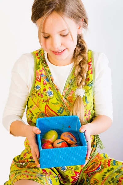 Chica joven mirando una caja con huevos de Pascua — Foto de Stock