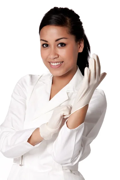 Porträtt av en beautifull indonesiska sjuksköterska att sätta handskar på — Stockfoto