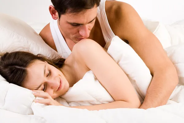 Young man kissing his girlfriend on her shoulder — Stock Photo, Image