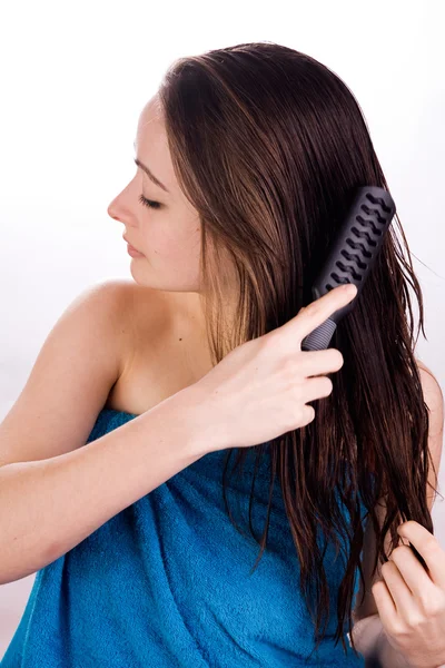 Mulher está arrumando seu cabelo — Fotografia de Stock