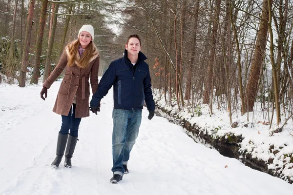 Junges Paar unternimmt einen Waldwinterspaziergang — Stockfoto