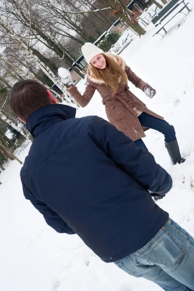 Coppia avendo una lotta con la palla di neve — Foto Stock