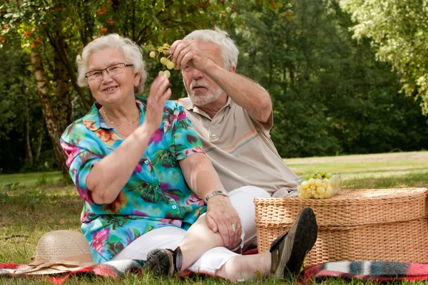 Casal de idosos comendo alguma fruta — Fotografia de Stock