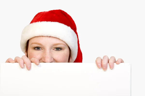 Christmas girl holding up a white sign for copyspace — Stock Photo, Image