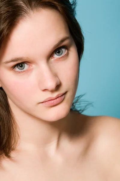 Retrato de una chica sobre un fondo azul —  Fotos de Stock