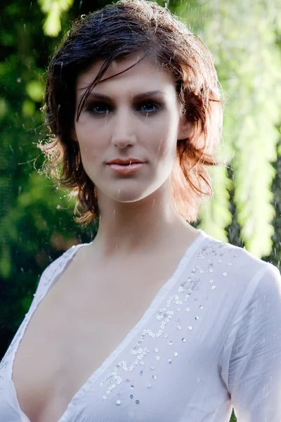 Brunette in white blouse standing in the rain — Stock Photo, Image