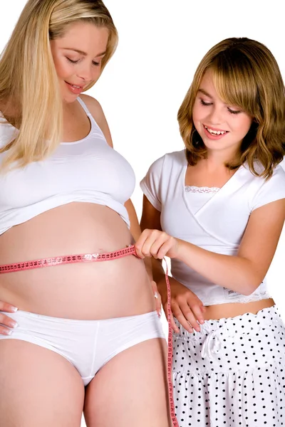Systerdotter hjälper hennes moster meassuring hennes gravid mage — Stockfoto
