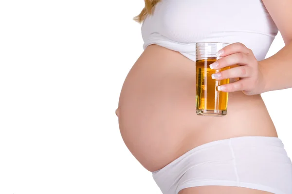 Presenting glass of apple juice in front of pregnant belly — Stock Photo, Image