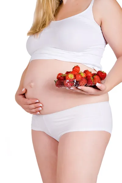 Presenting a bowl of strawberries in front of my pregnant belly — Stock Photo, Image