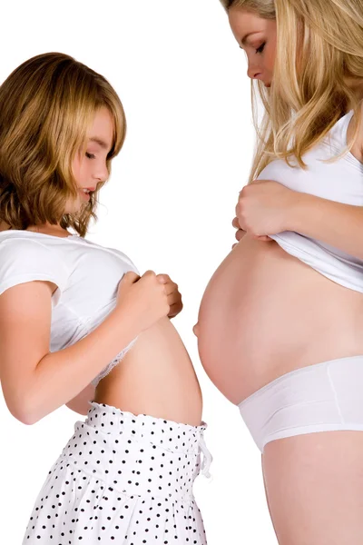 Comparing belly sizes between child and pregnant aunt — Stock Photo, Image